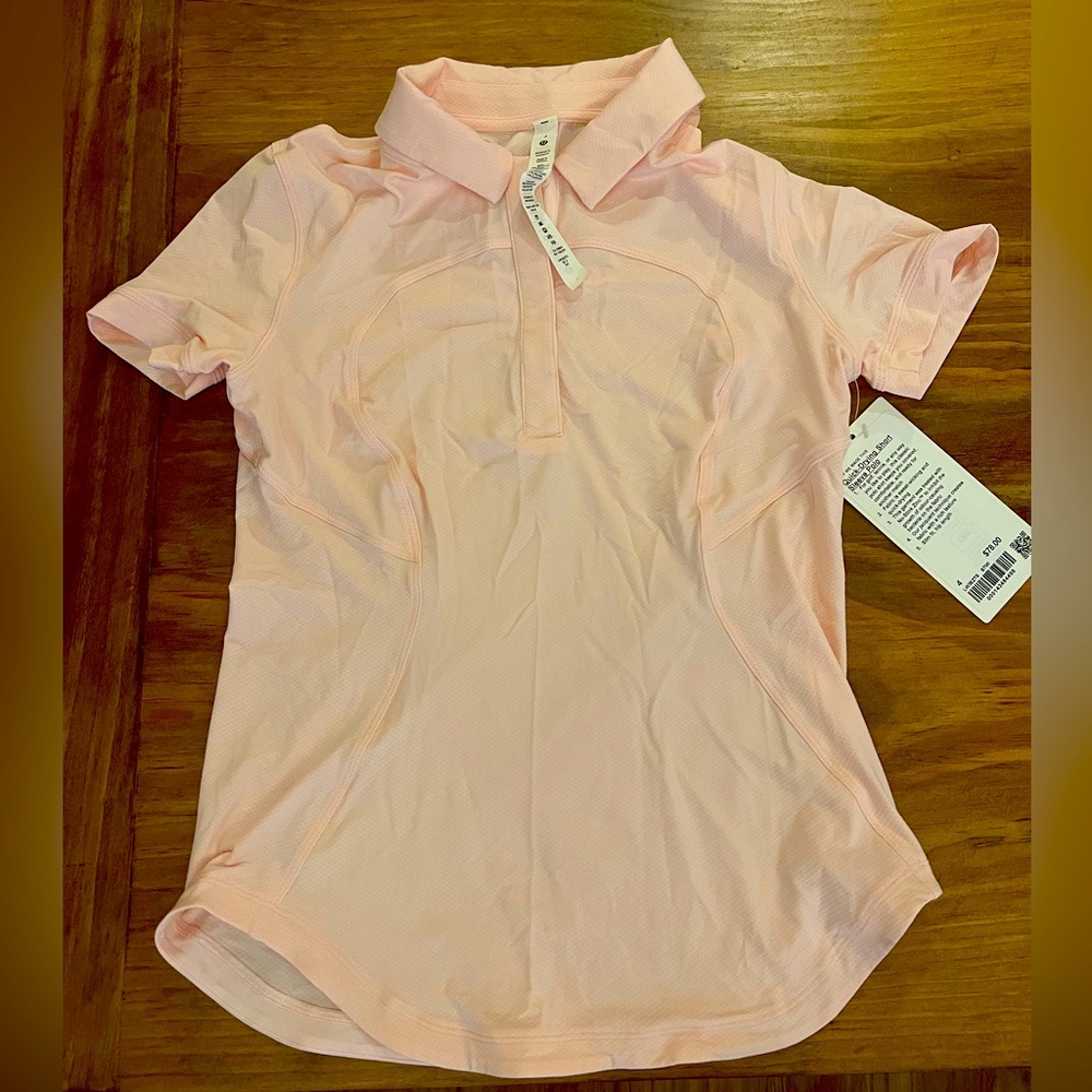 Lululemon. New with tags. Quick Dry. Short Sleeve. Pink women’s polo. Size 4.